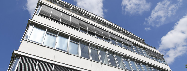 Fensterfront des Geschossbaus mit blauem Himmel