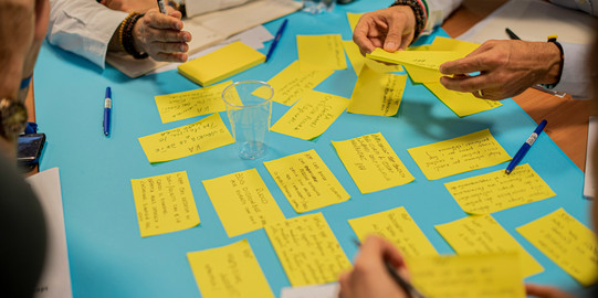 Ideenfindung durch Koproduktion durch Sammlung von Stichpunkten auf gelben Notizzetteln