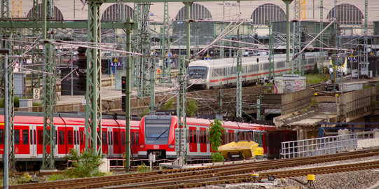 Zwei S-Bahnen und ein weiterer Zug befinden sich auf Gleisen an denen Bauarbeiten durchgeführt werden
